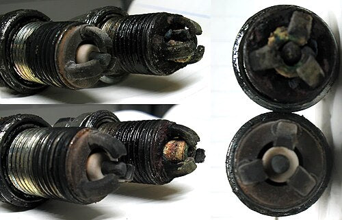 Comparison of a normally worn spark plug next to one with a cracked insulator and shortened electrode