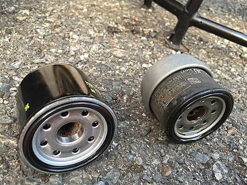 Comparison of a new oil filter next to a used, dirty oil filter
